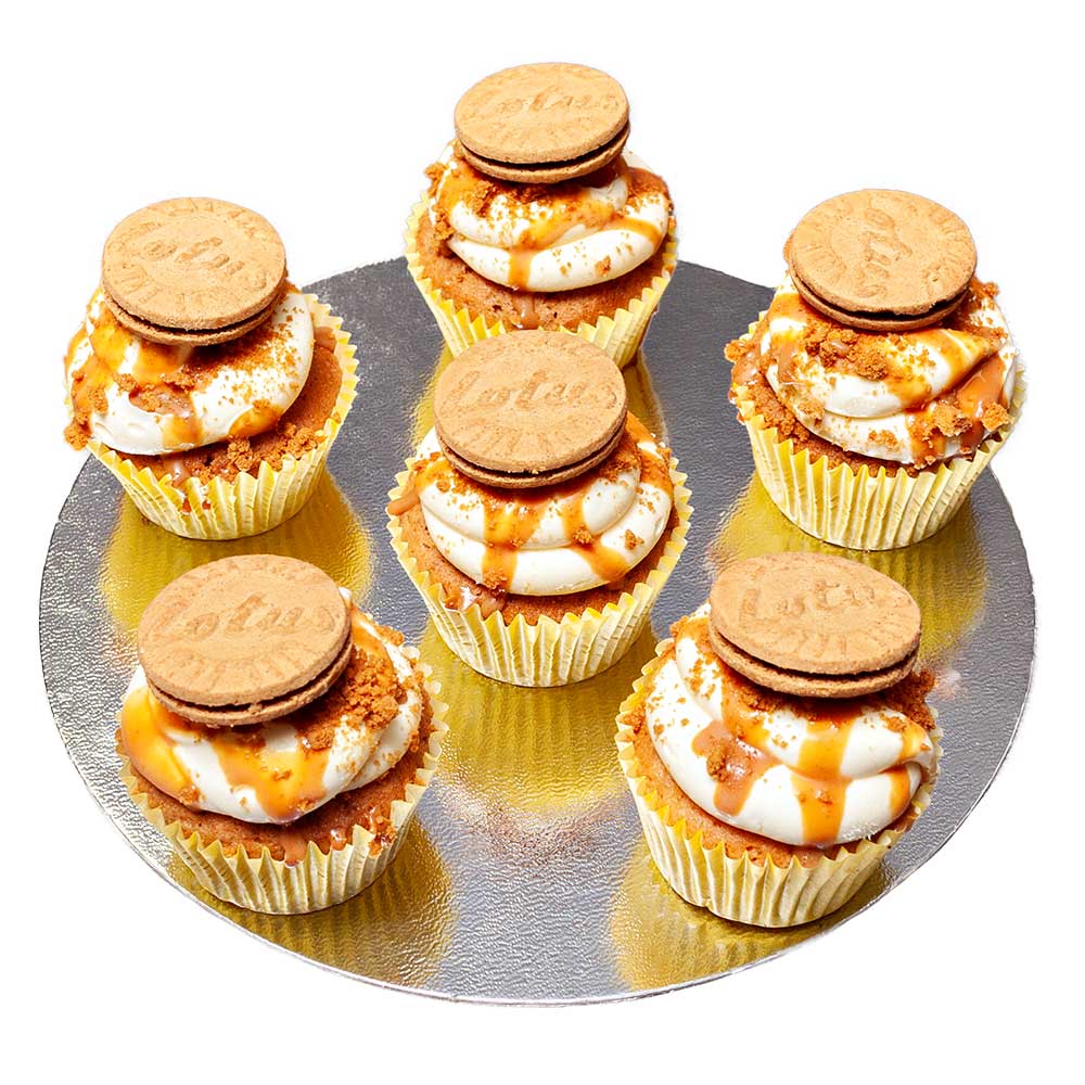 Six vanilla sponge cupcakes topped with butter cream drizzled with caramel and biscoff biscuit.