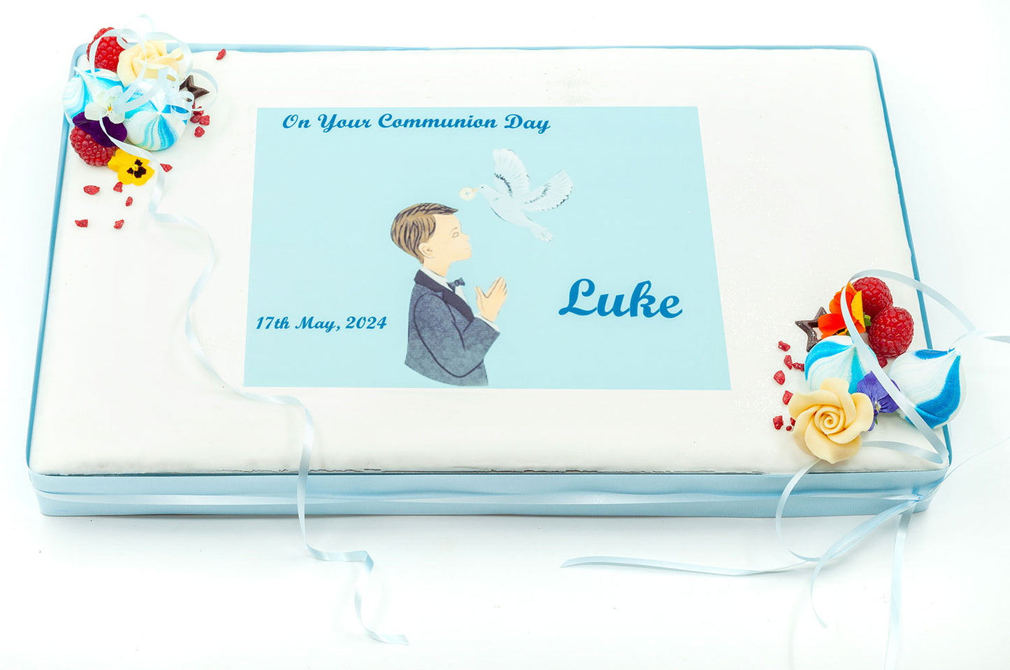 A large rectangular traybake cake decorated in blue for a child's Communion Day.
