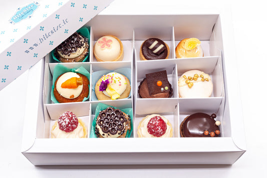 A luxury box of a selection of 12 artisan sweet canapés. Each one looks like a mini cake or cupcake.