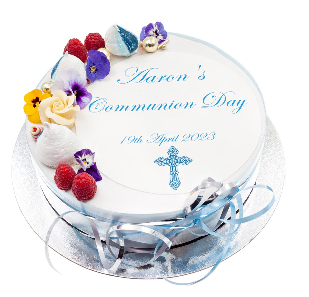 Communion cake topped with meringue swirls, edible flowers and summer fruits
