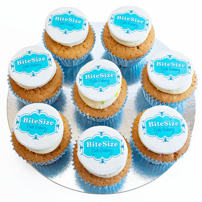 Six vanilla sponge cupcakes, each topped with butter cream and an edible disc with the BiteSize logo on it