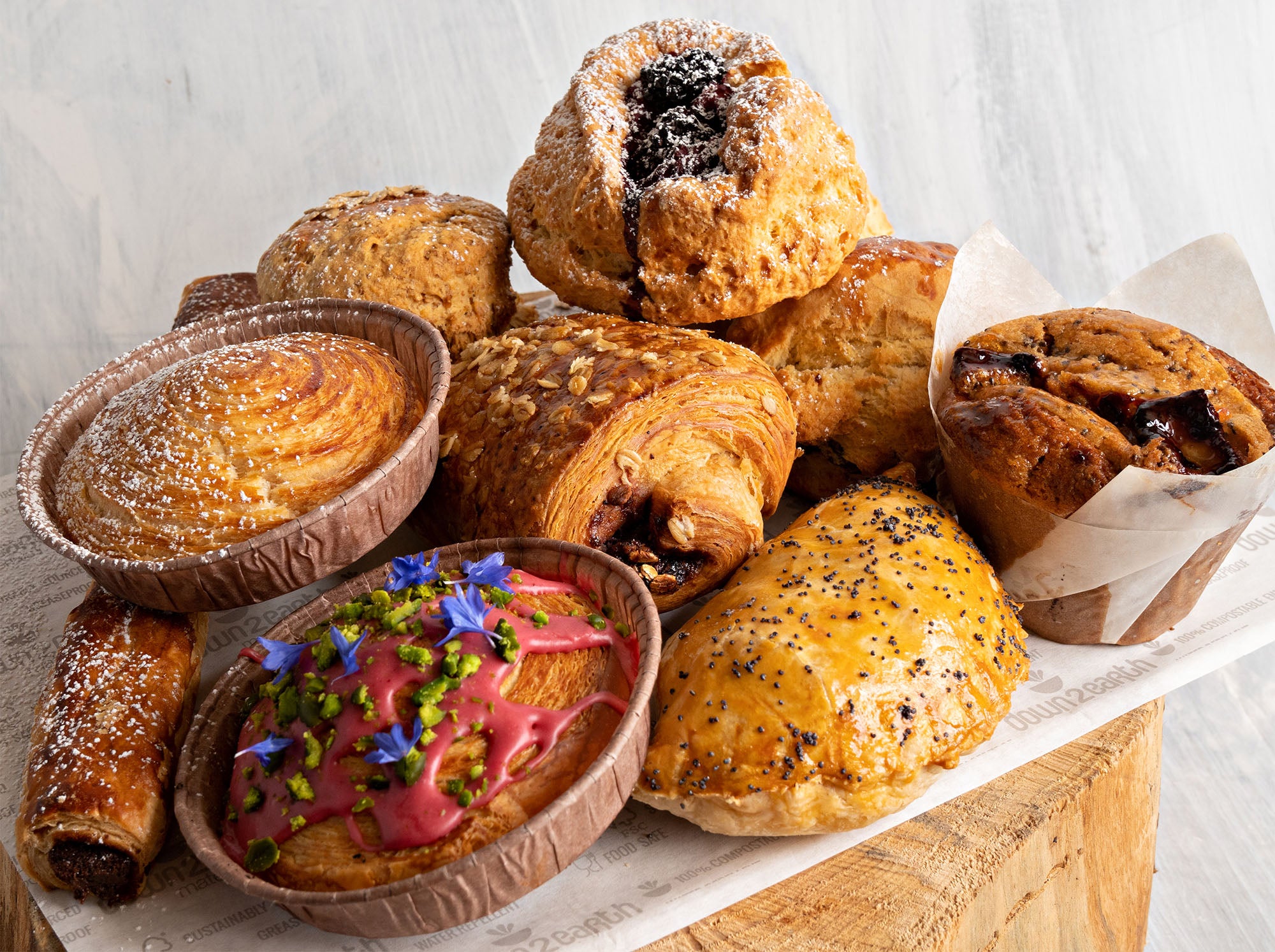 A selection of pastries, including a pain au chocolat, a muffin, a pasty and a couple of scones