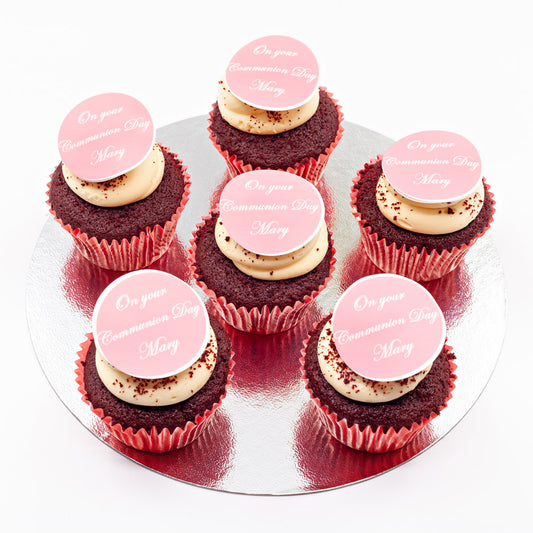 Six red velvet cupcakes, topped with butter cream and an edible disc with a Communion Day message on it