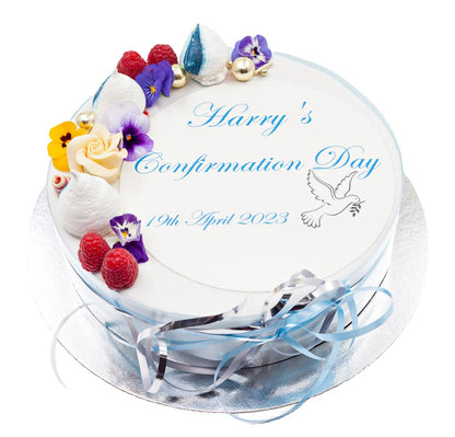 Confirmation cake decorated with meringue swirls, edible flowers and summer fruits.