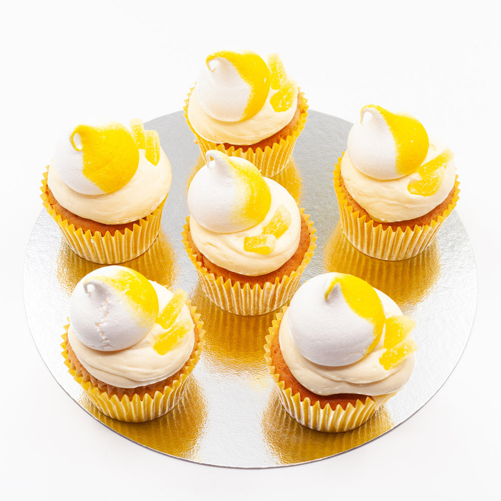 Six vanilla sponge cupcakes, each topped with butter cream, candied lemon and a lemon meringue swirl.